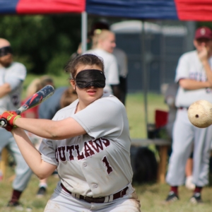 BCS Outlaw&#039;s Abigail Junek swings a bat towards the beep baseball hurtling towards her.