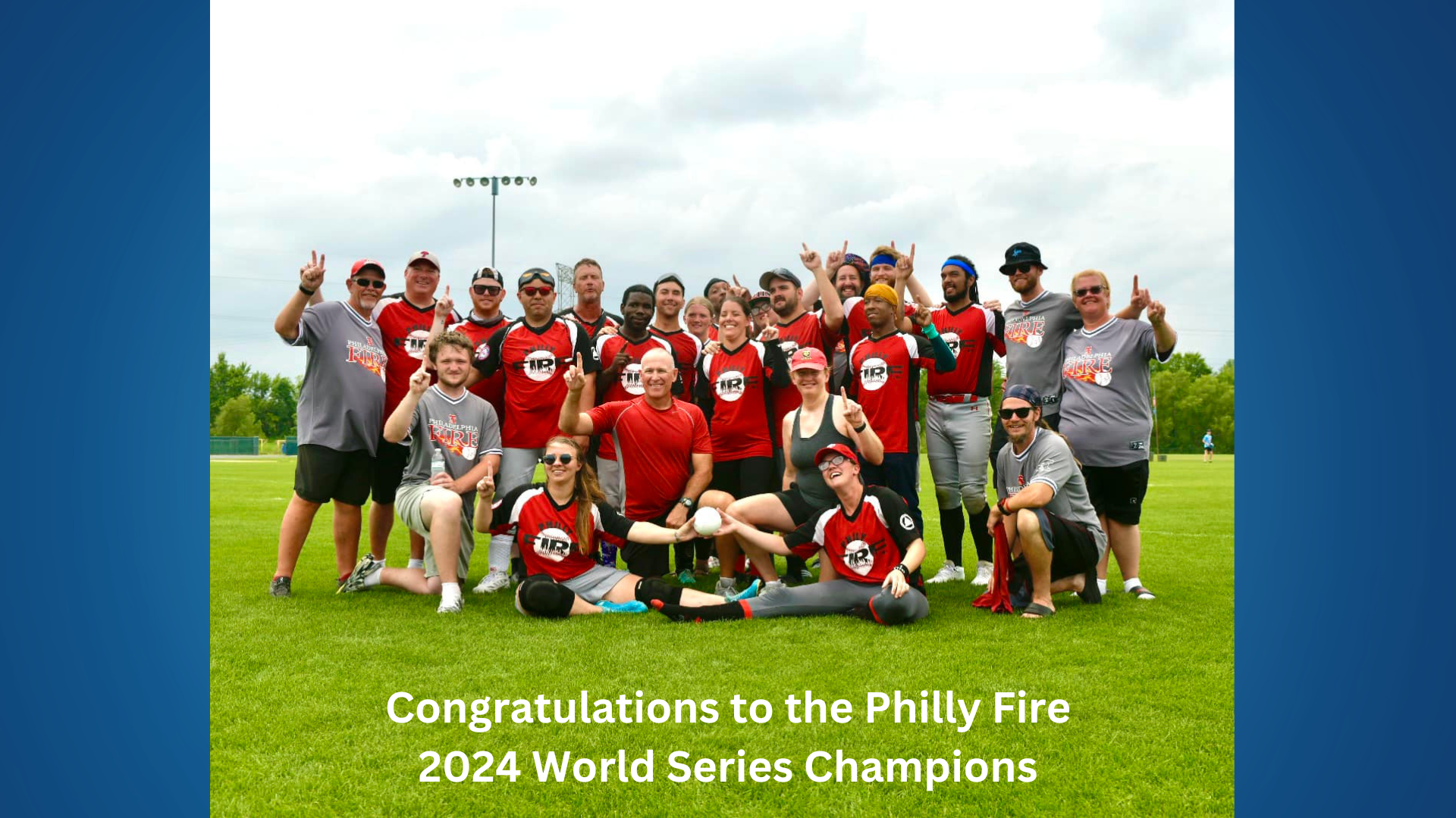 A group photo of the Philly Fire team after winning the 2024 World Series. They are smiling at the camera and holding "one" finger up.